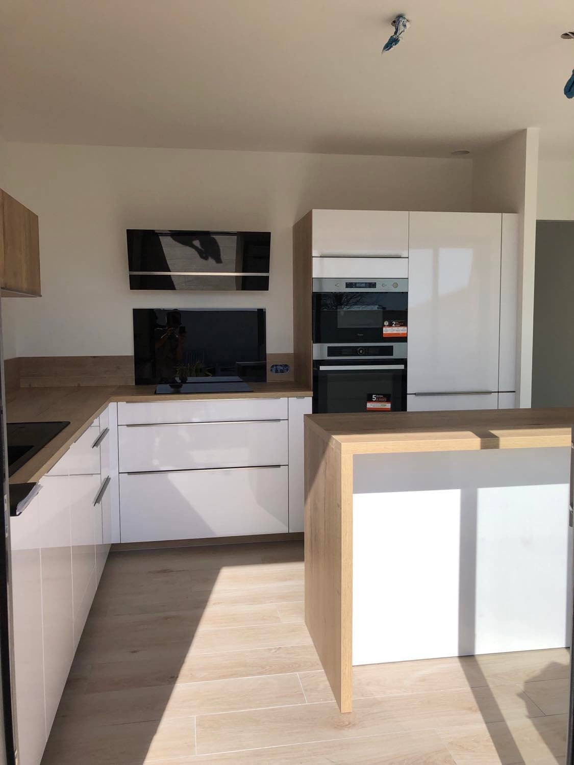 Rénovation d'une cuisine en L avec façade blanche et îlot en stratifié chêne bardolino au Crès