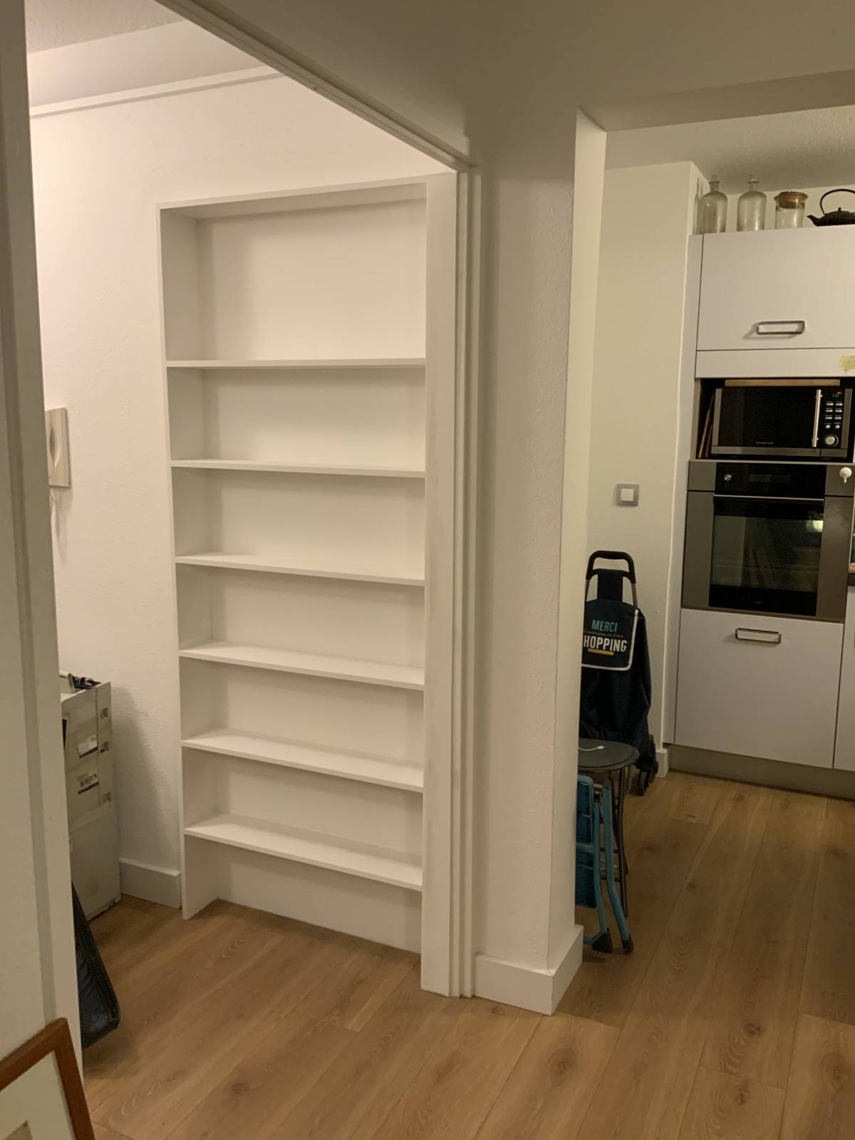 Conception et pose d’étagères en bois, avec aménagement et décoration au dos d’une porte