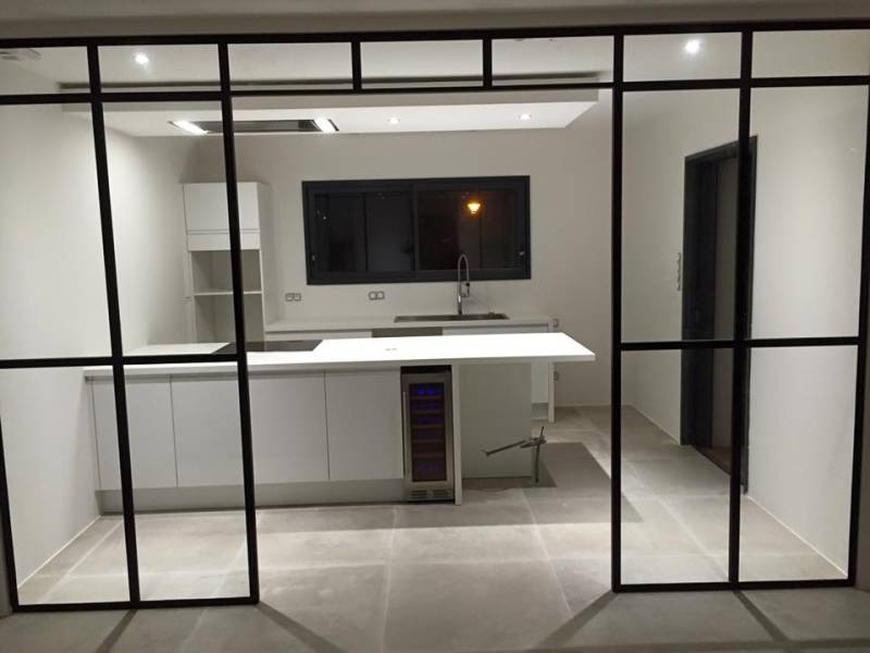 Création d'une cuisine 100% blanche avec îlot central, cave à vin et hotte aspirante en faux plafond à Montpellier