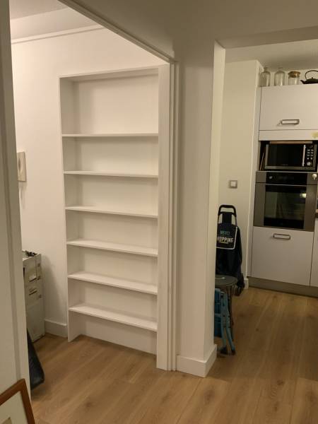 Conception et pose d’étagères en bois, avec aménagement et décoration au dos d’une porte